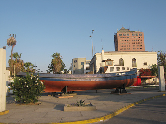 Lira-Allee, das Boot von der
                                    Seite gesehen, mit dem Firmenturm
                                    (torre Empressional) im Hintergrund