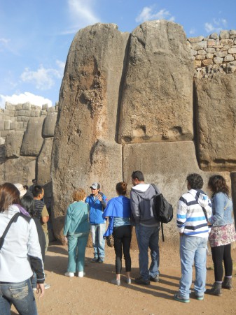 Cusco Sacsayhuamn, gigantischer Eckstein der Zickzackmauer mit Touristen