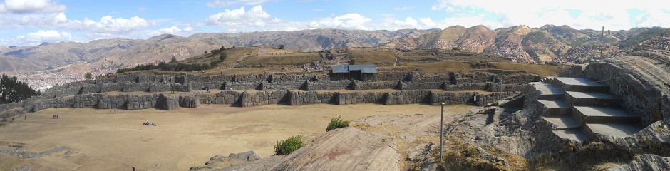 Sacsayhuamn (Cusco), en la colina aplanada, el trono gigante y la vista a los muros de de frente