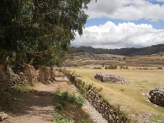 Cusco Sacsayhuamn 13, der Spaziergang zur "Zone X" (Laco, Mondtempel) mit einem ausgetrockneten Bach und Wiesen