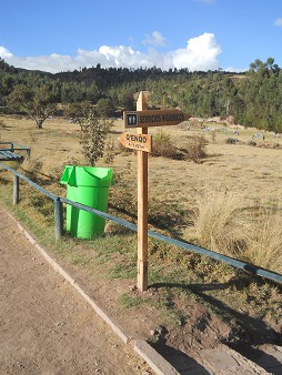 Cusco Sacsayhuamn 16: Der Weg zurck nach Cusco, ein Wegweiser nach Q'enqo - der Wegweiser zum Toilettenhuschen "Servicios higinicos"