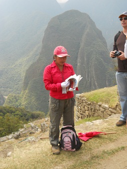 Eine Reiseleiterin auf Machu Picchu mit dem Putucusi-Berg im Hintergrund (die Reisefhrer kleiden sich immer in Rot, um besser sichtbar zu sein)