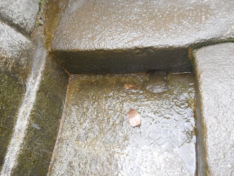 Wasserzisterne, in die flache Bodenplatte gehauen, und der unterste Stufenstein ist mit der Bodenplatte verbunden, Nahaufnahme