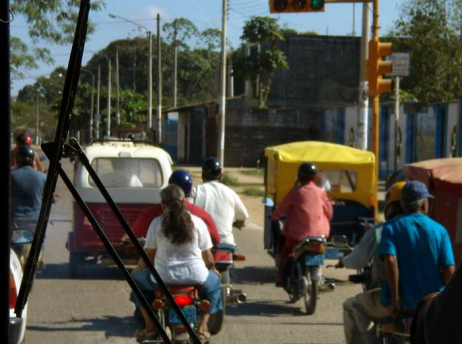 Puerto Maldonado, road with
                mototaxis and motorbikes